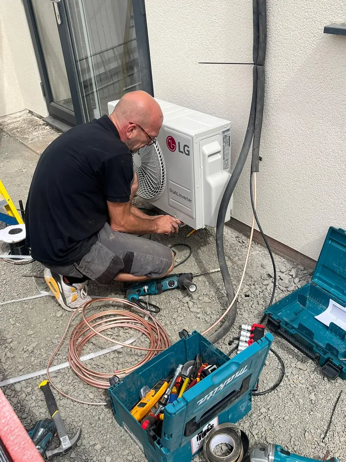 Air con repair engineer diagnosing a fault on an LG outdoor unit