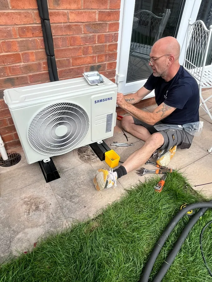 Engineer connecting a Samsung outdoor air conditioning condenser