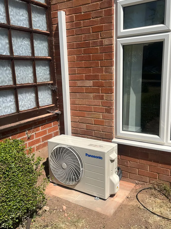 Panasonic outdoor condenser mounted beside a brick home