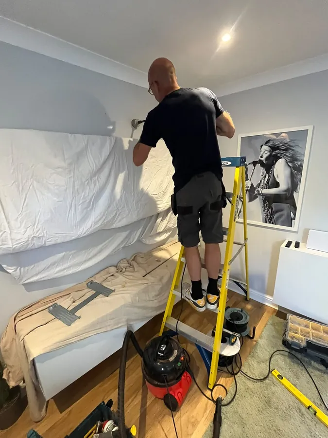 Tidy bedroom air conditioning installation with furnishings protected