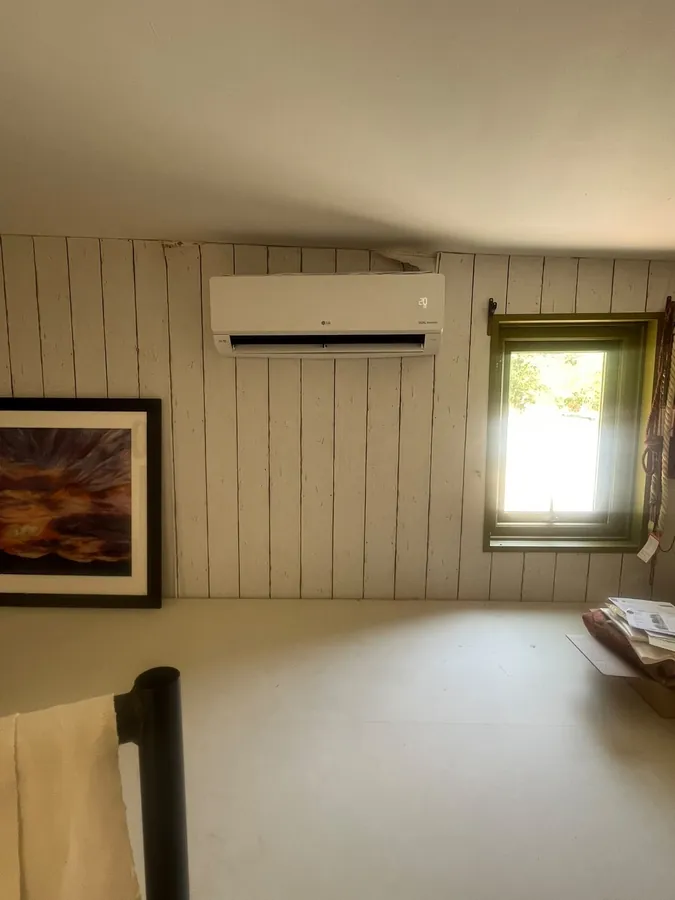 LG split system air conditioner in a timber-clad loft room