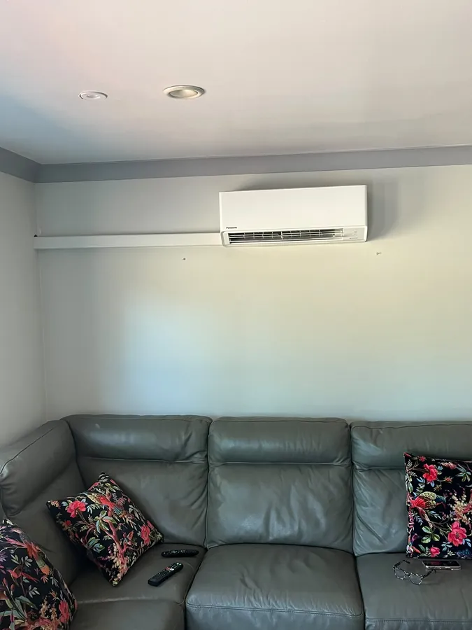 Panasonic split system air conditioner above a sofa with tidy trunking