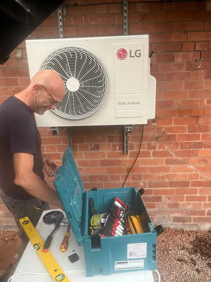 Engineer repairing an LG outdoor air conditioning unit in Hereford