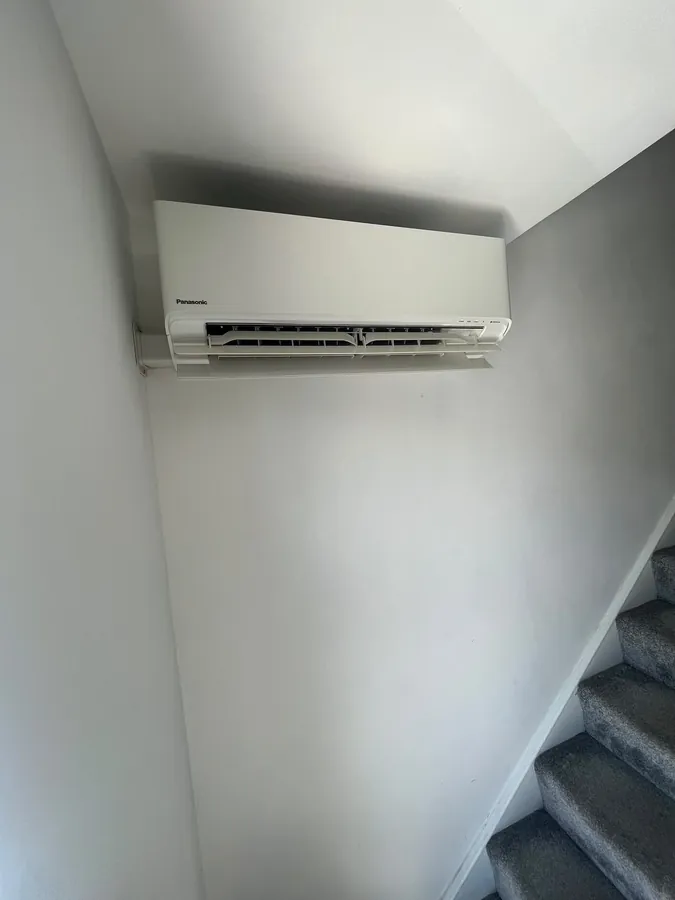 Panasonic split system air conditioner installed on a stairwell wall