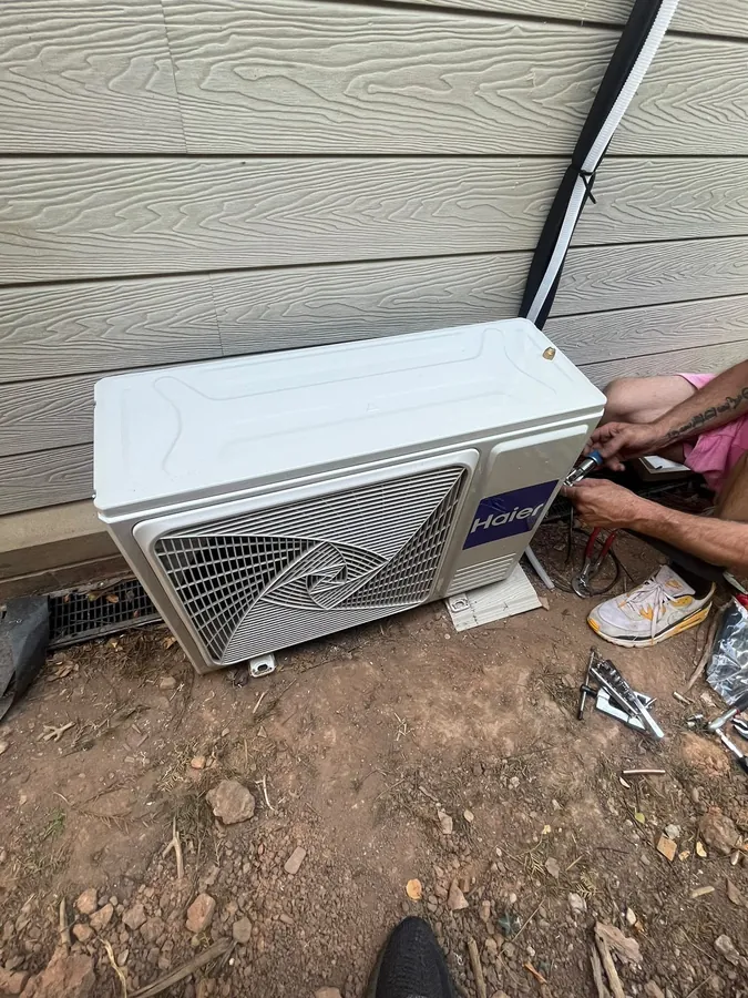 Haier outdoor air con unit being connected beneath exterior cladding