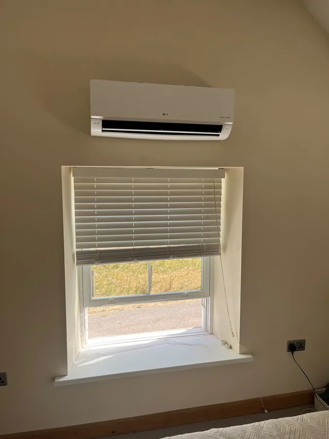 LG split system air conditioning unit above a bedroom window